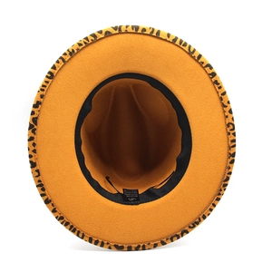 Detail view of ginger yellow fedora hat showing 65% cotton blend label and leopard brim