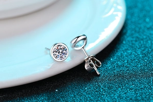 Macro close-up of a silver Moissanite stud earring featuring a classic round cut stone
