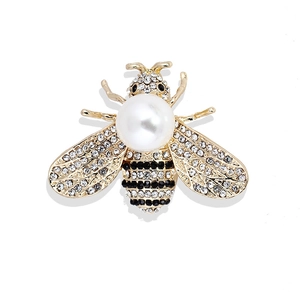 Exquisite gold alloy bee brooch with large white pearl and sparkling crystals on white background