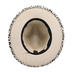 Detail shot of leopard print fedora hat interior showing 65% cotton and 35% polyester label