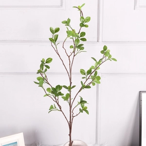 Detailed close-up of realistic artificial green milan leaves with brown branches for home decor