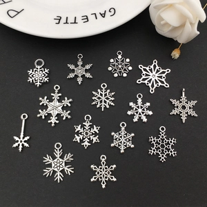 Set of 13 silver snowflake alloy pendants for DIY jewelry making on black background