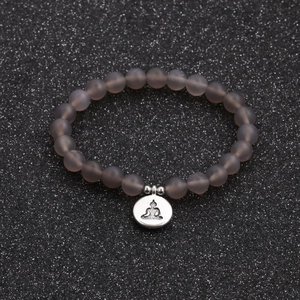Macro shot of 8mm matte grey agate beads and silver Buddha charm bracelet
