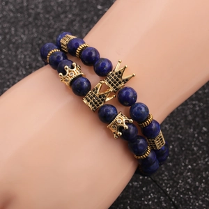 Dunkelblaues Perlenarmband-Set mit goldenen Kronenanhängern auf schwarzem Hintergrund
