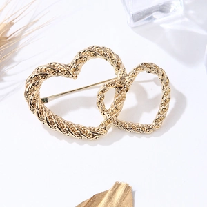 Elegant gold double heart brooch with twist texture for women on a white background