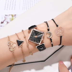 Close-up of stylish women's square quartz watch with black leather strap and stacked bracelets
