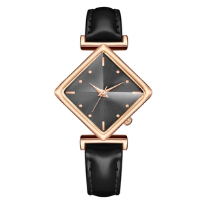 Detail of rose gold diamond-shaped watch case with dark grey sunray dial and black strap