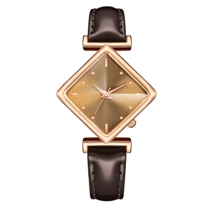Detail of rhombic rose gold watch case with dark brown leather strap on white background