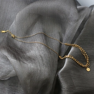 Close-up of double-layer 18K gold-plated titanium necklace with Lucky pendant detail