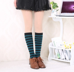 Detail of knee-high socks featuring horizontal black and green stripes in cotton knit