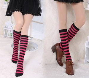 Detail of pink and black striped over-knee socks shown with brown leather shoes