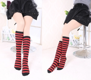 Detailed view of red and black horizontal striped knee-high knit socks in college style