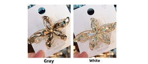 Close-up of K9 crystal starfish hair clip with gray and white rhinestones on card