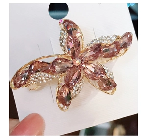 Macro shot of K9 crystal starfish hair clip with pink rhinestones on a gold base