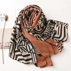 Detailed texture of lightweight geometric print shawl in caramel and black tones