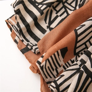 Detail of thin cotton linen scarf with ethnic geometric print in beige and orange