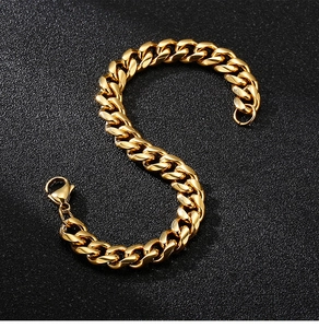 Detailed close-up of a gold Cuban link chain bracelet with a lobster clasp on black