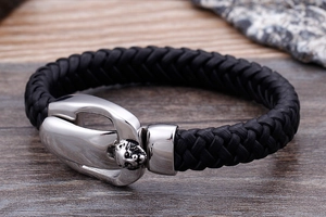 Detailed view of silver skull engraving on a black leather punk bracelet for men