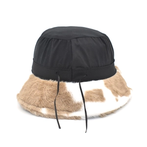 Black and cow print plush bucket hat with warm faux fur brim and adjustable drawstrings