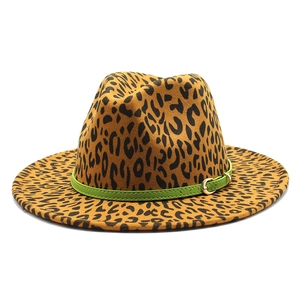 Détail d'un chapeau jazz léopard avec une bande en cuir vert et une boucle dorée