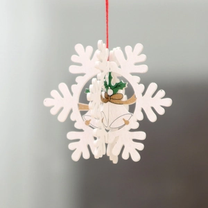 Detailed view of a white 3D laser-cut wooden snowflake ornament with bell pattern