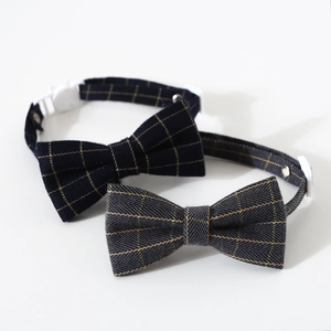 Detail view of plaid pet bowties with gold thread patterns and white safety buckles