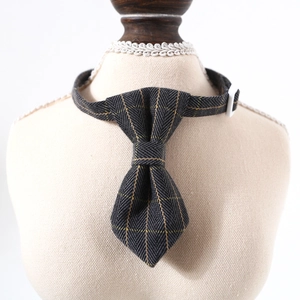 Detail of adjustable pet collar with grey herringbone pattern and yellow plaid bowtie
