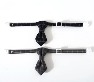 Detail of adjustable plaid pet collars with cat-shaped buckles in navy and grey