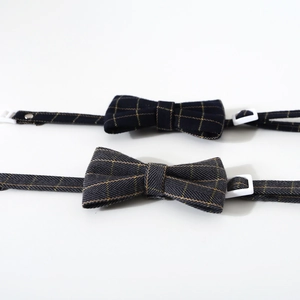 Detail view of adjustable plaid dog collars in blue and grey with metal buckles