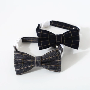 Detail of adjustable plaid pet bowtie collars in black and grey with white buckles