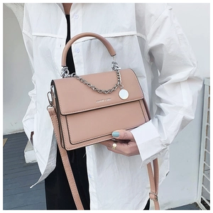 Detail view of pink leather flap bag featuring silver chain and adjustable shoulder strap