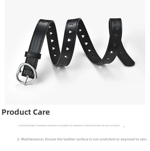 Detail of black leather belt featuring heart-shaped cutouts and silver heart buckle