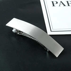 Macro view of silver geometric spring hair clip with matte brushed metal finish texture