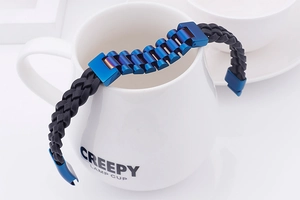 Detail of woven leather bracelet with blue metal watch strap style links and magnetic clasp