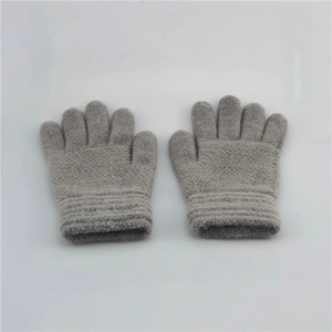 Detail of grey knitted winter gloves with ribbed cuffs for kids outdoor warmth