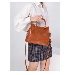 Brown crocodile pattern leather tote bag with detachable shoulder strap shown on model