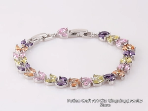 Detail of multi-color marquise-cut stones set in a white gold wheat ear bracelet