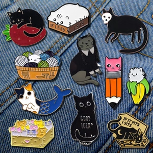 Collection of creative cat enamel pins displayed on denim, featuring funny cat designs