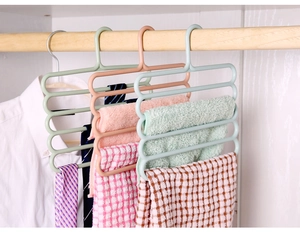 Detailed view of three 5-tier plastic hangers for ties and scarves in a closet