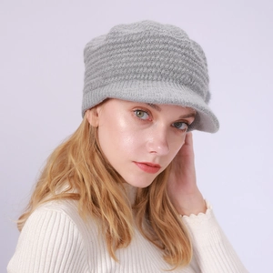 Details einer grauen Damen-Strickmütze mit Schirm und weicher, warmer Textur für Winter