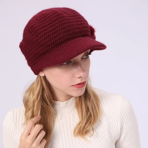 Nahaufnahme der weinroten Strickmütze mit Schirm für Damen mit warmer Winterwollstruktur