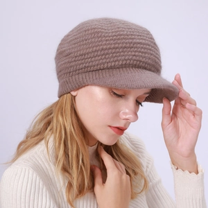 Nahaufnahme der braunen Strickmütze mit Schirm und dicker Wollstruktur für Damen