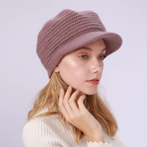 Detailansicht der lotusrosa Strickmütze mit Schirm und dicker Wollstruktur am Modell