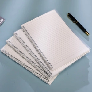 Close-up of lined inner pages of a transparent cover spiral notebook on a blue desk