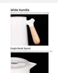 Detail view of the ergonomic wooden handle and anti-drip spout on a white thermal kettle