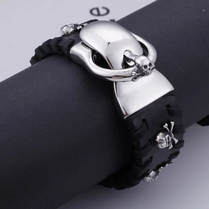 Punk style wide black braided leather bracelet with silver skull charms and studs