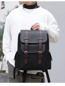 Close-up of black PU leather backpack with brown decorative straps on model shoulder