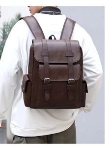 Detail shot of a large dark brown PU leather backpack on a model in a minimalist room