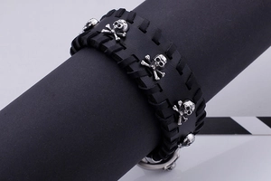 Close-up of punk style wide black leather bracelet with silver skull and crossbones stud detail