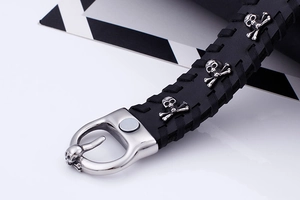 Close-up of black braided leather punk bracelet with skull studs and metal buckle detail